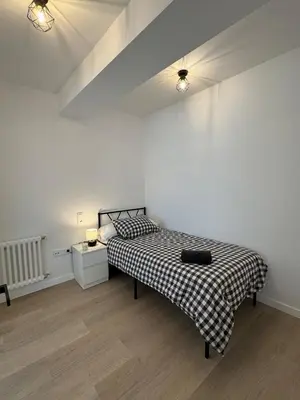 a bedroom with a bed with a black and white blanket at Civitas Augusta in Lugo