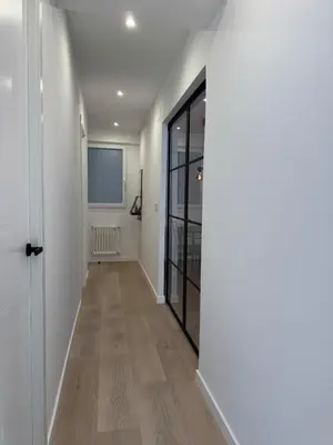 a hallway with white walls and a door with a window at Civitas Augusta in Lugo