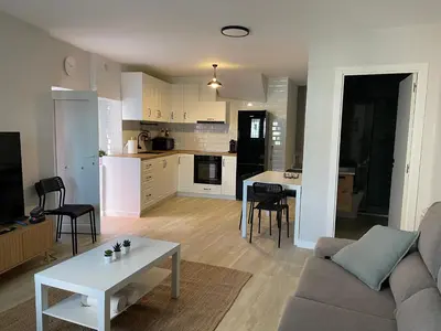a living room and kitchen with a couch and a table at Fogar en Soutelo in Forcarei