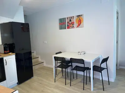 a kitchen with a white table with chairs and a refrigerator at Fogar en Soutelo in Forcarei