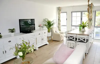 a living room with a white couch and a tv at Encanto de Oscos in San Martín de Oscos