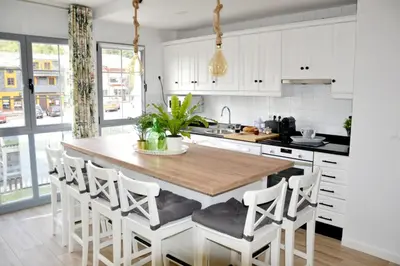 a kitchen with a wooden table and white cabinets at Encanto de Oscos in San Martín de Oscos