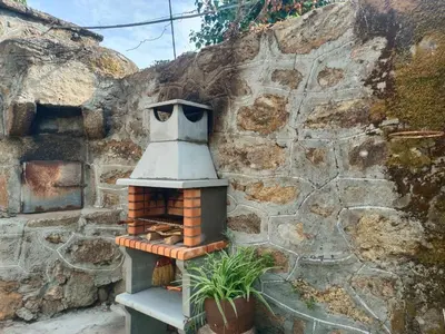 a small brick oven sitting next to a stone wall at A Casiña do Anselmiño in Celanova