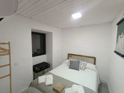 a small bedroom with two beds and a window at A Casiña do Anselmiño in Celanova