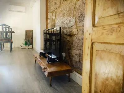 a room with a bench and a stone wall at A Casiña do Anselmiño in Celanova