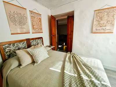 a bedroom with a bed and some pictures on the wall at A Casiña do Anselmiño in Celanova