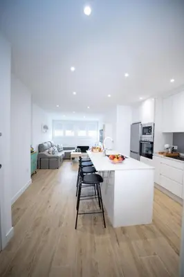 a white kitchen with a white island in a room at Nido PADRON in Padrón