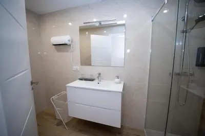 a white bathroom with a sink and a shower at Nido PADRON in Padrón