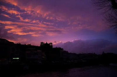 a sunset over a city and a river with buildings at Nido PADRON in Padrón