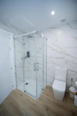 a bathroom with a toilet and a glass shower at Nido PADRON in Padrón