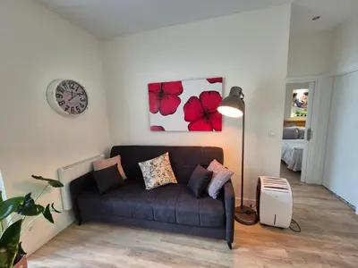 a living room with a couch and a clock on the wall at Grândola in Ourense