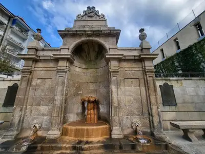 a fountain with a statue in the middle of a building at Grândola in Ourense
