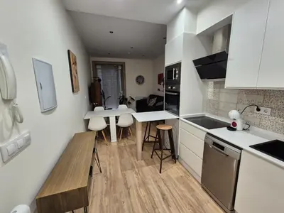 a kitchen with white cabinets and a table in it at Grândola in Ourense