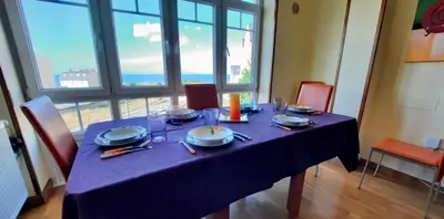 a table with a blue table cloth and plates and candles at El mirador del mar in Foz
