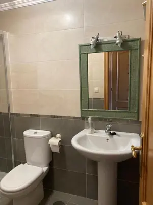 a bathroom with a toilet and a sink and a mirror at El mirador del mar in Foz