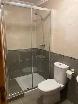 a bathroom with a shower with a toilet and a glass shower door at El mirador del mar in Foz