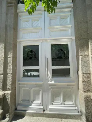 a white door with two windows in a building at Apartamento Paseo Malecón Planta 1 in Monforte de Lemos