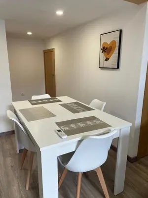 a white table with white chairs and a picture on the wall at Apartamento Paseo Malecón Planta 1 in Monforte de Lemos