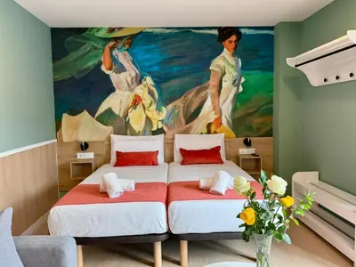 a bedroom with two beds in front of a painting at Luxury Singular Blue in Santiago de Compostela