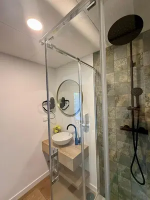 a bathroom with a shower and a sink and a mirror at Luxury Singular Blue in Santiago de Compostela