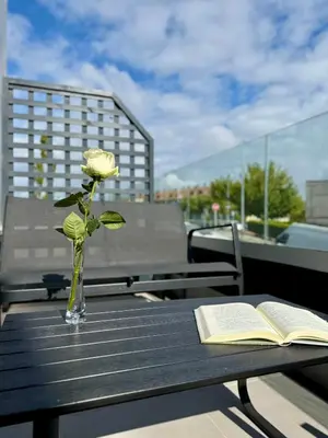 a vase with a flower and a book on a table at Luxury Singular Blue in Santiago de Compostela