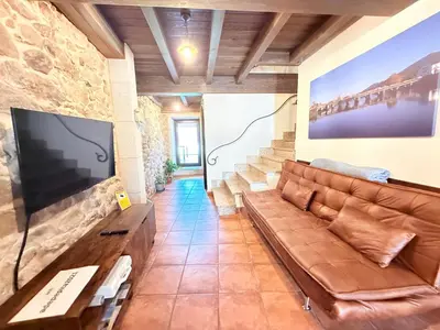 a room with two chairs and a stone wall at A de Pepita, Rural House in Padrón by URent in Padrón