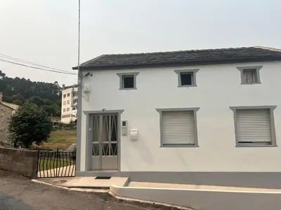 a white house with a door and a fence at Casa das Pasadiñas-Burela in Burela de Cabo