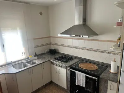 a kitchen with a stove top oven next to a sink at Casa das Pasadiñas-Burela in Burela de Cabo