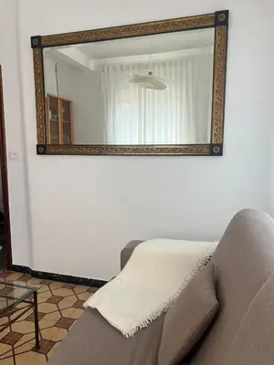 a mirror on a wall in a living room with a couch at Casa das Pasadiñas-Burela in Burela de Cabo