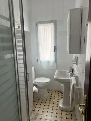 a white bathroom with a toilet and a sink at Casa das Pasadiñas-Burela in Burela de Cabo