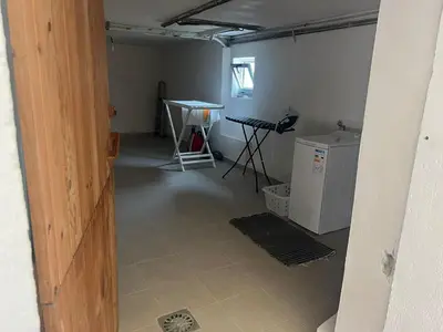 an empty garage with a table and a refrigerator at Casa das Pasadiñas-Burela in Burela de Cabo