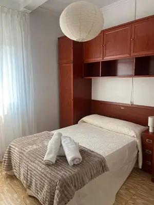 a bedroom with a bed with two towels on it at Casa das Pasadiñas-Burela in Burela de Cabo