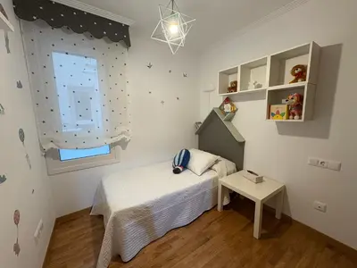 a small bedroom with a bed and a window at Piso Rente o Mar in Foz