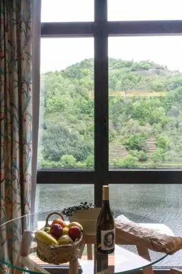 a bottle of wine and a basket of fruit in front of a window at Loureira in Pincelo