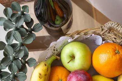 a basket of fruit on a table next to a plant at Loureira in Pincelo