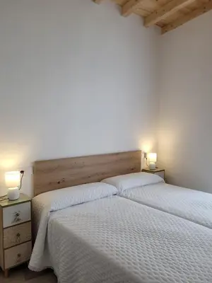 two beds in a bedroom with two lamps on tables at Vaniria 3 Apartamentos Nuevos in Foz