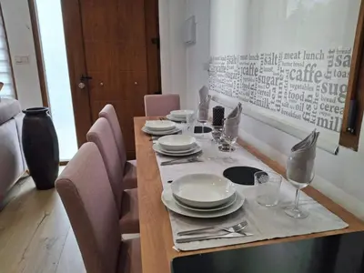 a wooden table with plates and glasses on it at La casa de Teresa in Santiago de Compostela
