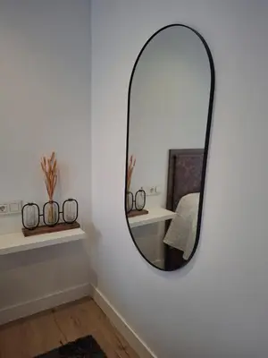a mirror on a white wall in a room at La casa de Teresa in Santiago de Compostela