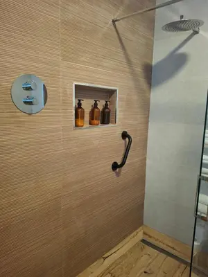 a bathroom with a shower with bottles on the wall at La casa de Teresa in Santiago de Compostela