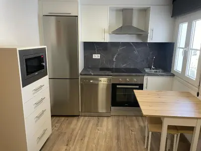 a kitchen with stainless steel appliances and a wooden table at Apartamento Paseo Malécon Planta 3 in Monforte de Lemos