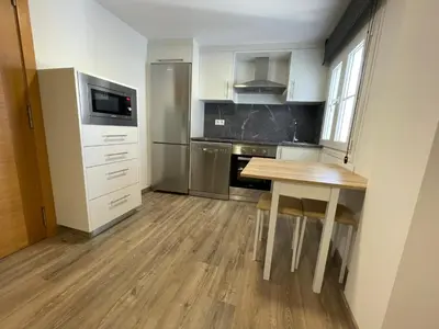 a kitchen with a wooden table and a wooden floor at Apartamento Paseo Malécon Planta 3 in Monforte de Lemos