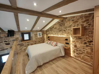a bedroom with a bed and a stone wall at A Casa de Salvador - retiro rural con alma gallega in Vedra