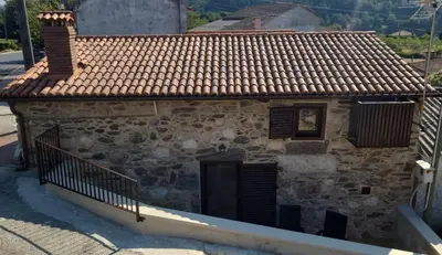 a stone building with a door on a street at A Casa de Salvador - retiro rural con alma gallega in Vedra