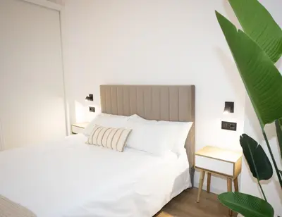 a bedroom with a white bed and a side table at Dorian Suites in Monforte de Lemos