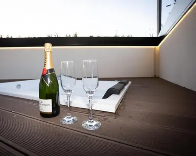 a bottle of champagne and two wine glasses on a table at Dorian Suites in Monforte de Lemos