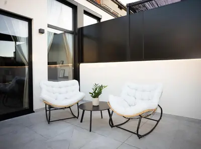 two white chairs and a table on a patio at Dorian Suites in Monforte de Lemos