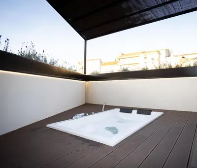 a bathroom with a white bath tub on a wooden floor at Dorian Suites in Monforte de Lemos