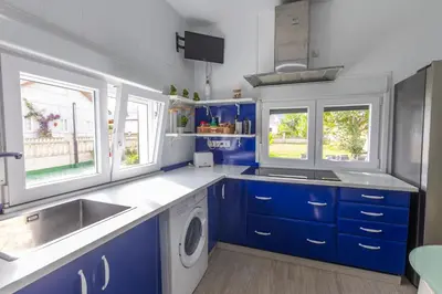 a blue and white kitchen with a sink and a dishwasher at Villa Las Catedrales - Frente a la playa - Amplio jardín - Piscina in Barreiros