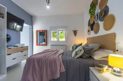 a bedroom with a bed with a blanket on it at Villa Las Catedrales - Frente a la playa - Amplio jardín - Piscina in Barreiros