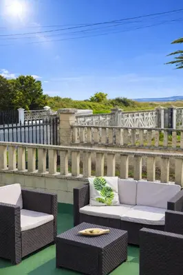 a patio with two chairs and a couch and a table at Villa Las Catedrales - Frente a la playa - Amplio jardín - Piscina in Barreiros